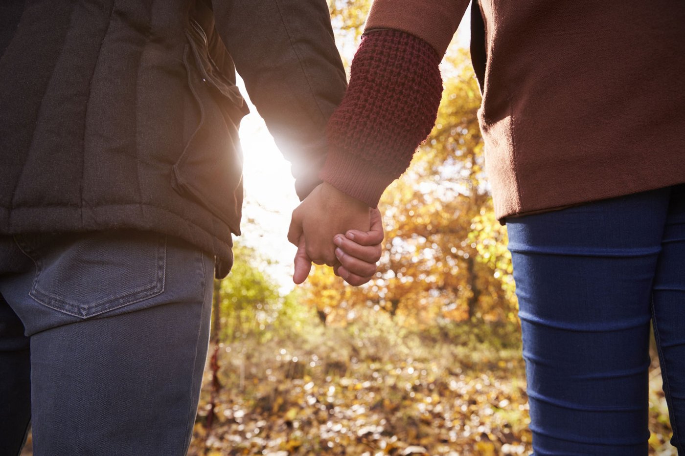 Couple holding hands in autumn light
