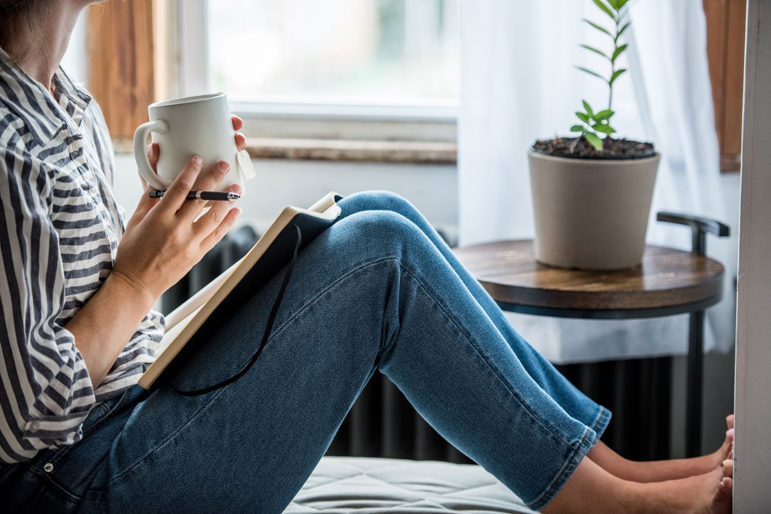 Woman with coffee and journal in a reflective moment