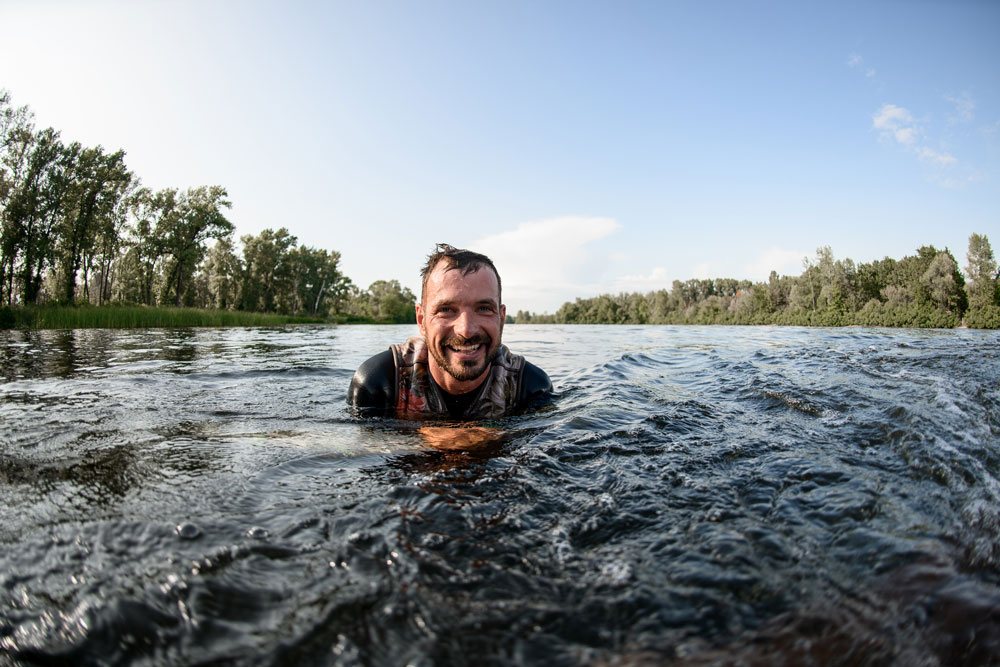 Man smiling in open water on a bright day